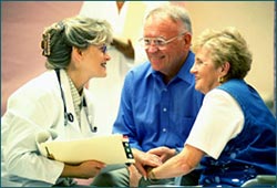 Female doctor consulting with couple about insurance pre-verification.